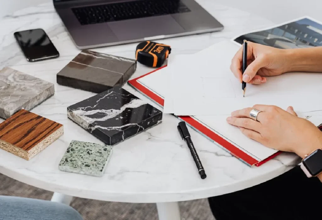 Designer sketching an interior design plan with material samples