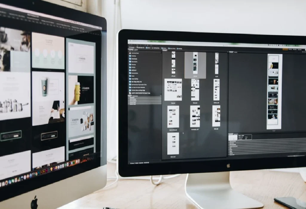 Web design layouts displayed on dual computer monitors